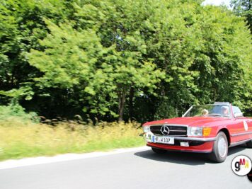 Roter Mercedes-Benz Oldtimer-Cabrio auf Landstraße zwischen grünen Bäumen während der ADAC Oldtimerfahrt Hessen-Thüringen