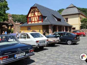 Mehrere Oldtimer-Limousinen aus den 1960er und 1970er Jahren parken auf dem Innenhof einer Burg während der ADAC Oldtimerfahrt Hessen-Thüringen