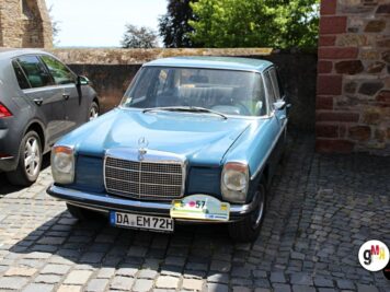 Mercedes-Benz Oldtimer in Hellblau parkt auf Kopfsteinpflaster bei der ADAC Oldtimerfahrt Hessen-Thüringen neben modernem Fahrzeug