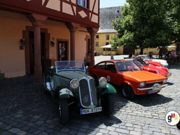 Mehrere Oldtimer-Fahrzeuge verschiedener Epochen parken auf einem Marktplatz vor Fachwerk- und Altstadt-Häusern bei der ADAC Oldtimerfahrt Hessen-Thüringen