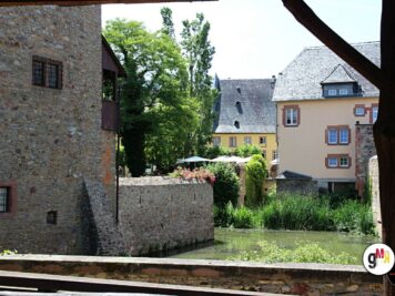Historische Steingebäude und farbige Häuser an einem Fluss während der ADAC Oldtimerfahrt Hessen-Thüringen