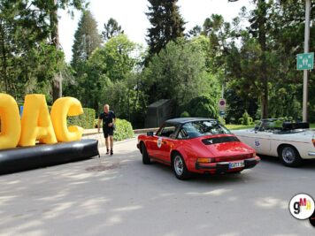 Rote Oldtimer-Sportcabrios und weiße Limousine neben großen gelben DAC-Schriftzügen bei der ADAC Oldtimerfahrt Hessen-Thüringen