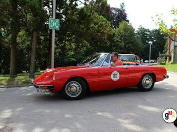 Roter Oldtimer-Sportwagen mit Startnummer 80 bei der ADAC Oldtimerfahrt Hessen-Thüringen, Fahrer in baumbestandener Straße