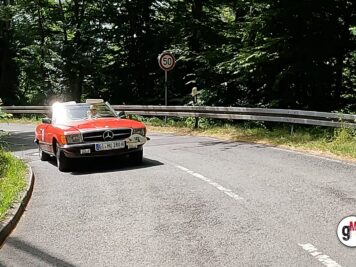 Mercedes-Benz SL Cabrio in Rot fährt auf kurvenreicher Landstraße während der ADAC Oldtimerfahrt Hessen-Thüringen