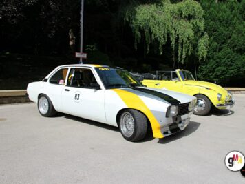 Zwei Oldtimer-Limousinen mit Startnummern parken auf einem Platz, eine weiß-gelb, eine gelb, umgeben von grünem Laub bei der ADAC Oldtimerfahrt Hessen-Thüringen