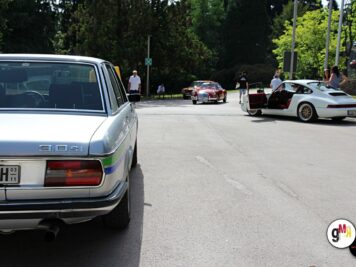 Oldtimer-Limousine im Vordergrund und weitere Klassiker auf Parkplatz bei ADAC Oldtimerfahrt Hessen-Thüringen, Teilnehmer zwischen Fahrzeugen