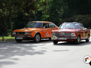 Zwei BMW-Oldtimer mit Rallyenummern nebeneinander auf einer Straße vor grüner Kulisse bei der ADAC Oldtimerfahrt Hessen-Thüringen