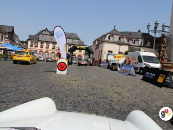 Marktplatz einer historischen Stadt mit gelben Oldtimer-Taxis, ADAC-Fahnen und Teilnehmern der Oldtimerfahrt Hessen-Thüringen