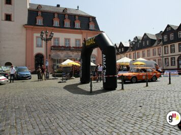 Oldtimer-Sportwagen auf Marktplatz mit historischen Gebäuden und schwarzem ADAC-Startbogen zur Rallye Hessen-Thüringen