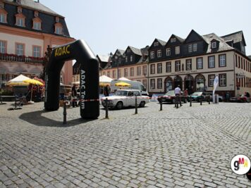 Oldtimer-Limousine fährt durch historischen Marktplatz unter schwarzem ADAC-Bogen bei der Oldtimerfahrt Hessen-Thüringen