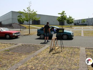 Teilnehmer der ADAC Oldtimerfahrt Hessen-Thüringen 2022 posieren mit seinen Fahrzeugen auf Parkplatz vor Industriegebäude