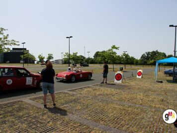 Oldtimer-Sportwagen in Rot und weitere Fahrzeuge auf Parkplatz bei ADAC Oldtimerfahrt mit Teilnehmern und Zeitstationen