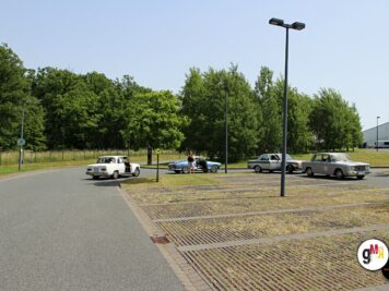 Mehrere Oldtimer-Limousinen parken auf einem Parkplatz bei der ADAC Oldtimerfahrt Hessen-Thüringen, umgeben von Grünanlagen