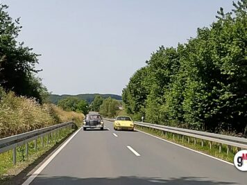 Zwei Oldtimer fahren auf einer Autobahn durch grüne Landschaft während der ADAC Oldtimerfahrt Hessen-Thüringen