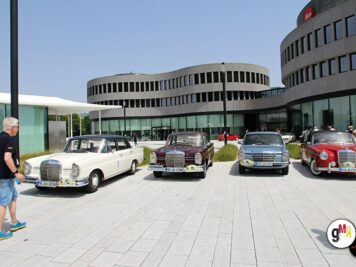 Mehrere Oldtimer-Limousinen und ein Cabrio auf einem Platz vor moderner Architektur bei der ADAC Oldtimerfahrt Hessen-Thüringen