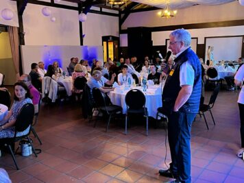 Veranstalter spricht zu Teilnehmern der ADAC Oldtimerfahrt Hessen-Thüringen beim Abendessen im Saal