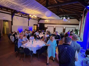 Festsaal mit zahlreichen Gästen an runden Tischen bei der Abendveranstaltung der ADAC Oldtimerfahrt Hessen-Thüringen