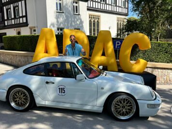 Porsche 911 Carrera mit Startnummer 115 bei der ADAC Oldtimerfahrt Hessen-Thüringen, Fahrer neben Sportwagen vor großem gelbem Schriftzug