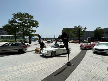 Teilnehmer der ADAC Oldtimerfahrt Hessen-Thüringen 2022 präsentieren ihre Fahrzeuge auf einem Platz mit Oldtimern und modernen Autos