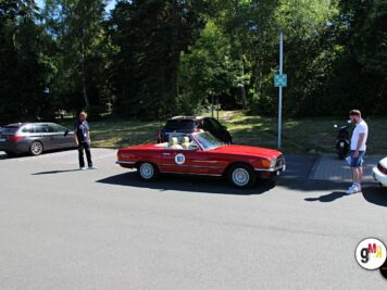 Rotes Oldtimer-Cabrio mit Startnummer bei der ADAC Oldtimerfahrt Hessen-Thüringen, Teilnehmer und Begleiter rundherum auf Parkplatz