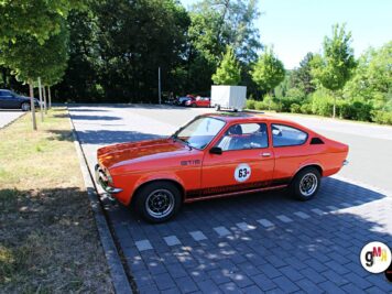 Roter Ford-Oldtimer mit Startnummer auf gepflastertem Parkplatz bei der ADAC Oldtimerfahrt Hessen-Thüringen