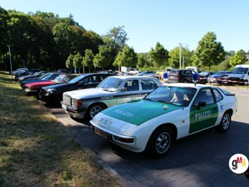 Porsche 924 mit Polizei-Lackierung und weitere Oldtimer-Fahrzeuge auf Parkplatz bei ADAC Oldtimerfahrt Hessen-Thüringen