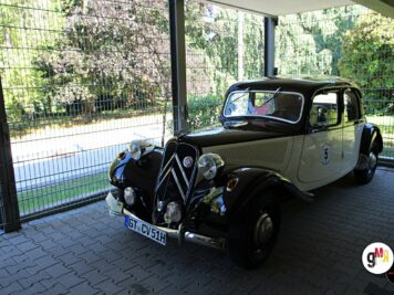 Zwei Oldtimer-Limousinen unter einem Carport, schwarze Citroën mit Kennzeichen, grüne Umgebung sichtbar