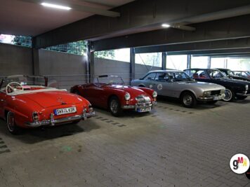 Mehrere Oldtimer-Sportwagen in roten und silbernen Farben stehen in einer Parkgarage zur ADAC Oldtimerfahrt Hessen-Thüringen