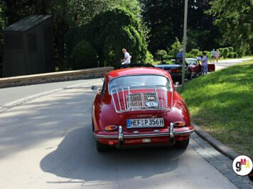 Roter Oldtimer-Käfer von hinten bei der ADAC Oldtimerfahrt Hessen-Thüringen, weitere Fahrzeuge und Besucher im Park