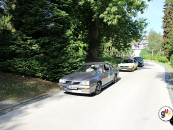 Oldtimer-Sportcoupé mit Teilnehmern in Kolonne auf Allee-Straße während ADAC Oldtimerfahrt Hessen-Thüringen, Fachwerkhaus im Hintergrund