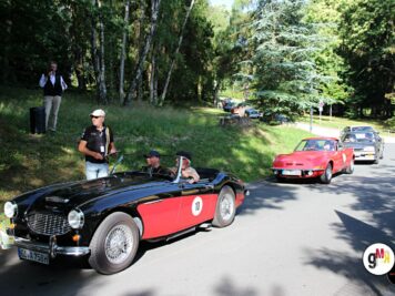 Schwarzroter Oldtimer-Sportwagen mit Startnummer bei der ADAC Oldtimerfahrt Hessen-Thüringen, gefolgt von weiteren klassischen Fahrzeugen auf waldiger Strecke