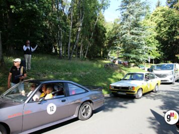 Oldtimer-Cabrio mit Startnummer fährt auf Waldstraße, dahinter Youngtimer-Limousine in Gelb, Organisatoren und Zuschauer bei ADAC Oldtimerfahrt Hessen-Thüringen