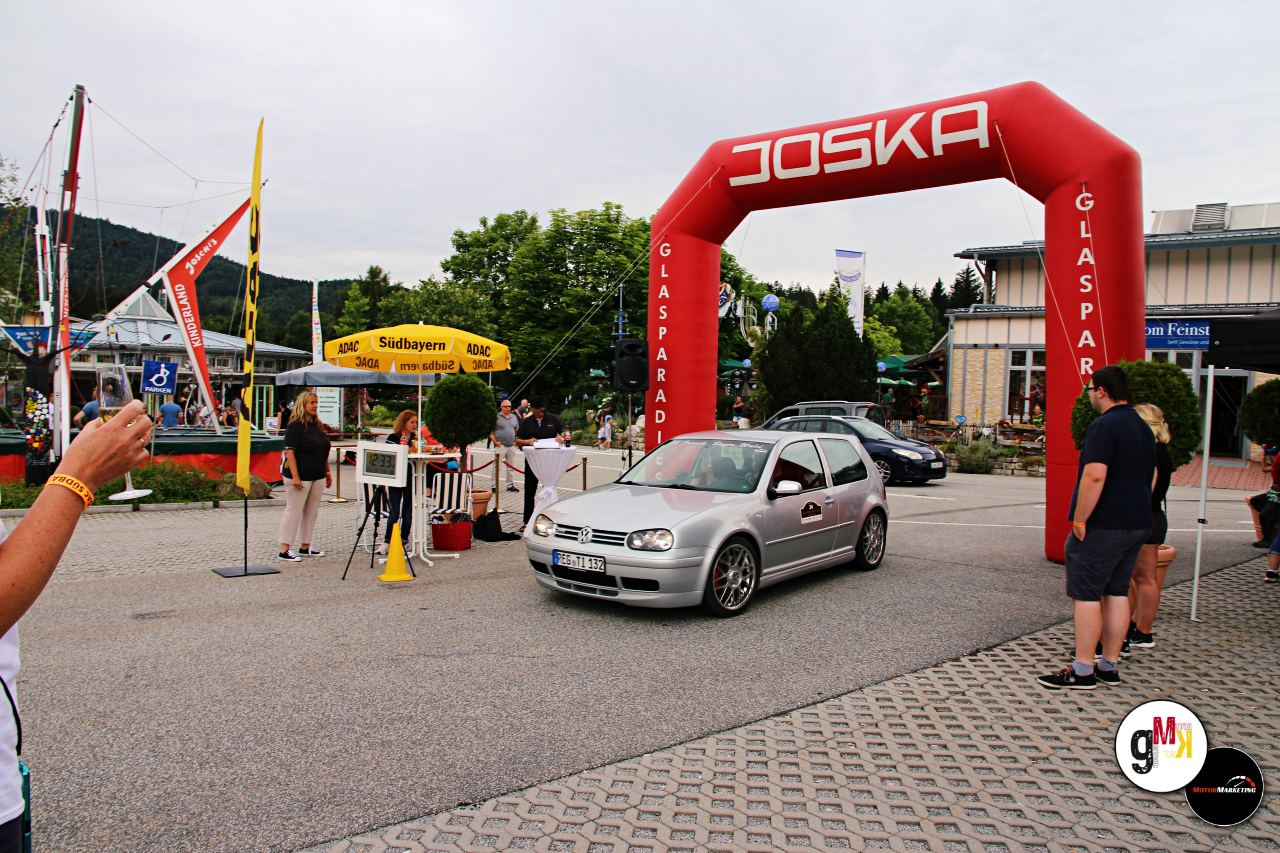 Silberner Youngtimer-Kompaktwagen fährt unter das rote JOSKA-Tor bei der ADAC Youngtimer Tour Südbayern
