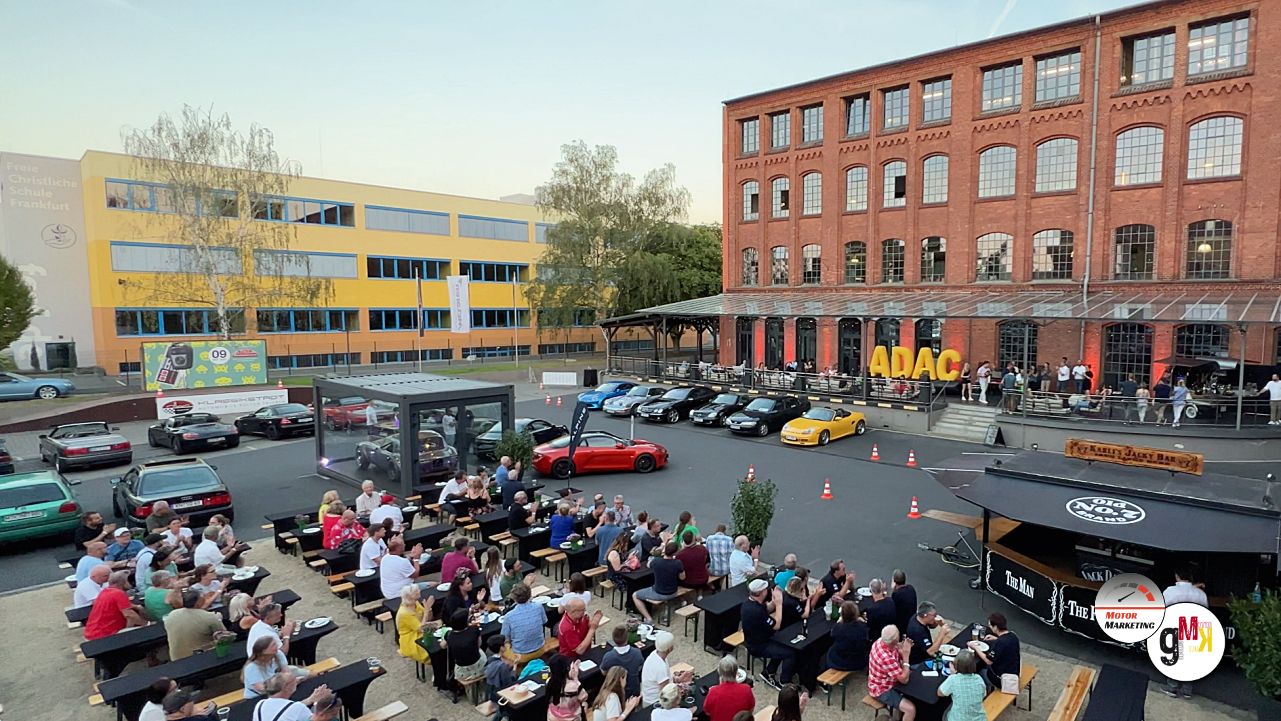 Zahlreiche Besucher und bunte Youngtimer auf dem Platz vor historischen Industriegebäuden bei der Klassikstadt-Veranstaltung