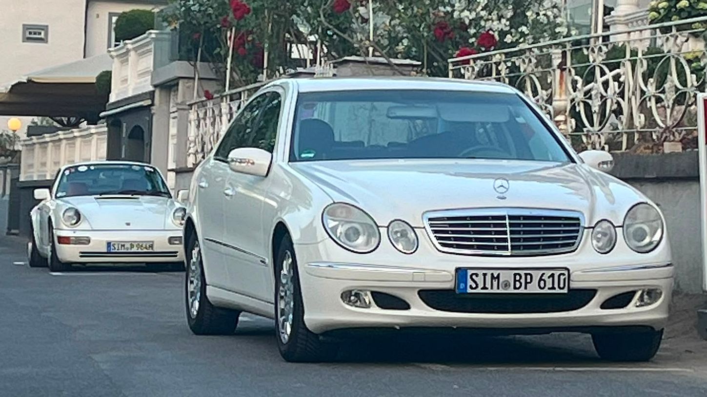 Zwei weiße Oldtimer-Limousinen parken vor einer Villa mit blühenden Rosen, Generationen-Duell bei der Food Rallye