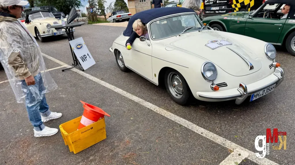 Weißer Porsche 356 bei der Bewertung an der ADAC Gardasee Klassik, Fahrer sitzt am Steuer, Prüfer daneben mit Klemmbrett