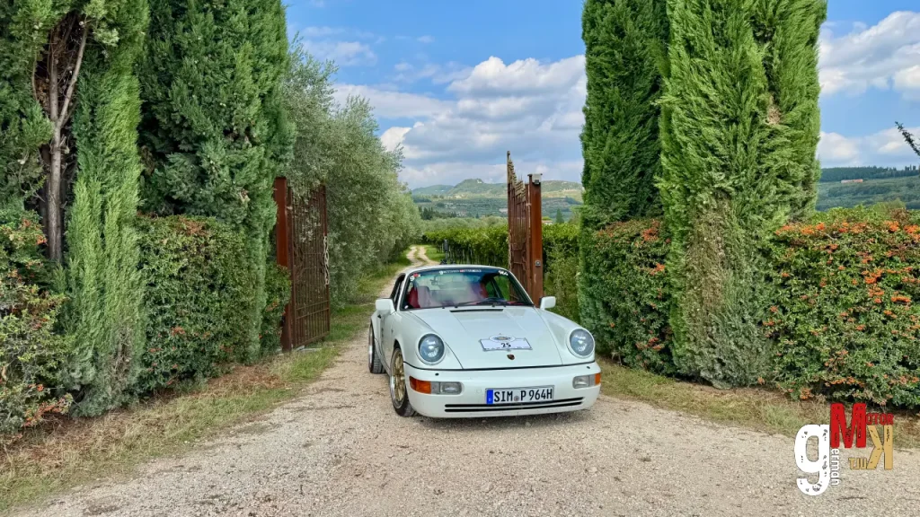 Weißer Oldtimer-Sportwagen auf Kiesweg zwischen Zypressenalleen in italienischer Landschaft bei ADAC Gardasee Klassik