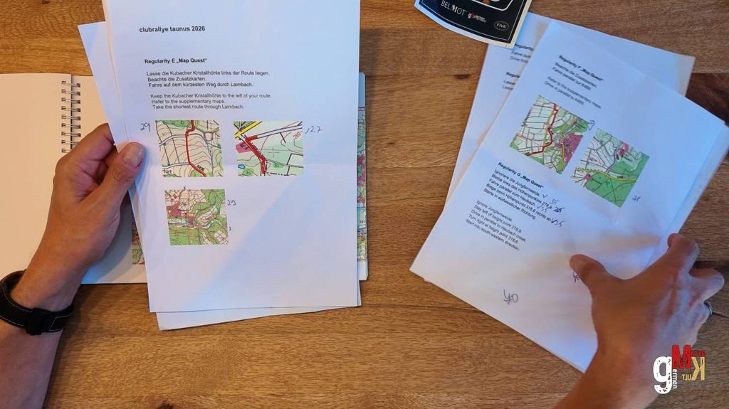 Teilnehmer studiert Rallyekarten und Routenunterlagen mit Streckenmaps für die Taunus-Rallye auf Holztisch