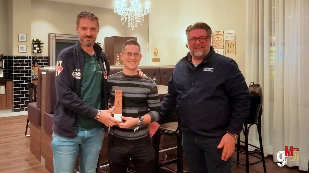 Drei Teilnehmer präsentieren eine Auszeichnung bei der Club Rallye Taunus in einem eleganten Innenraum